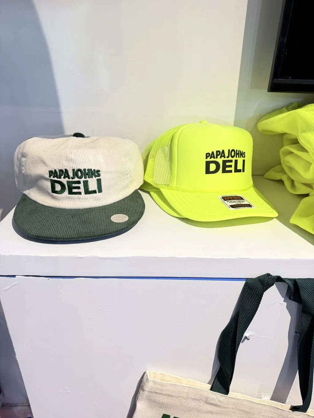 Decorated caps and a tote displayed at a Merch Troop event